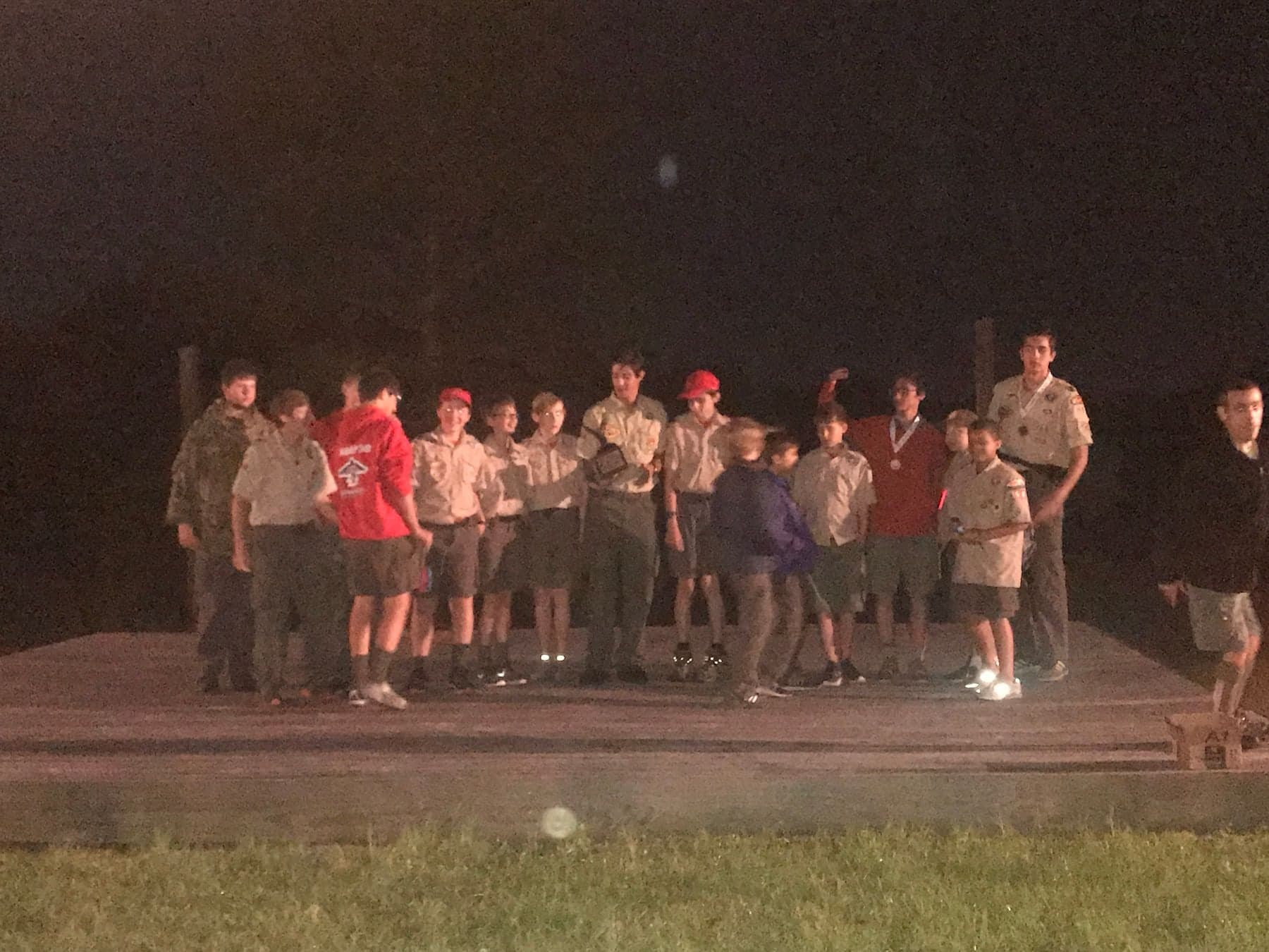 The Scouts of Troop 50 gathered on the camporee stage at night as Colin Raby holds the trophy