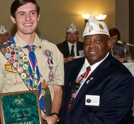 Colin Raby in his Eagle Scout uniform holding the Eagle Scout of the Year plaque beside an American Legion officer