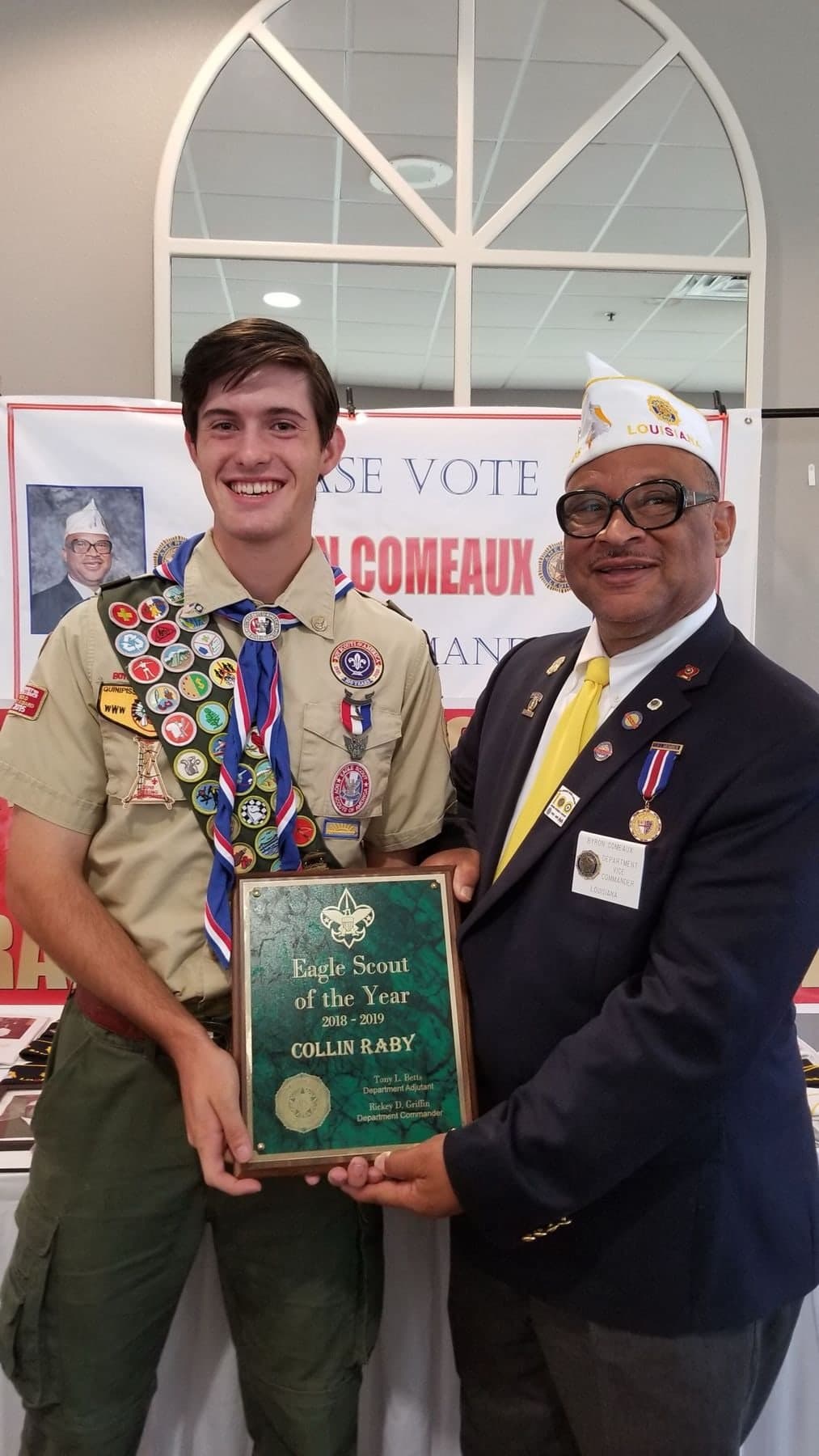 Colin Raby in his Eagle Scout uniform accepting the Eagle Scout of the Year plaque from an American Legion officer