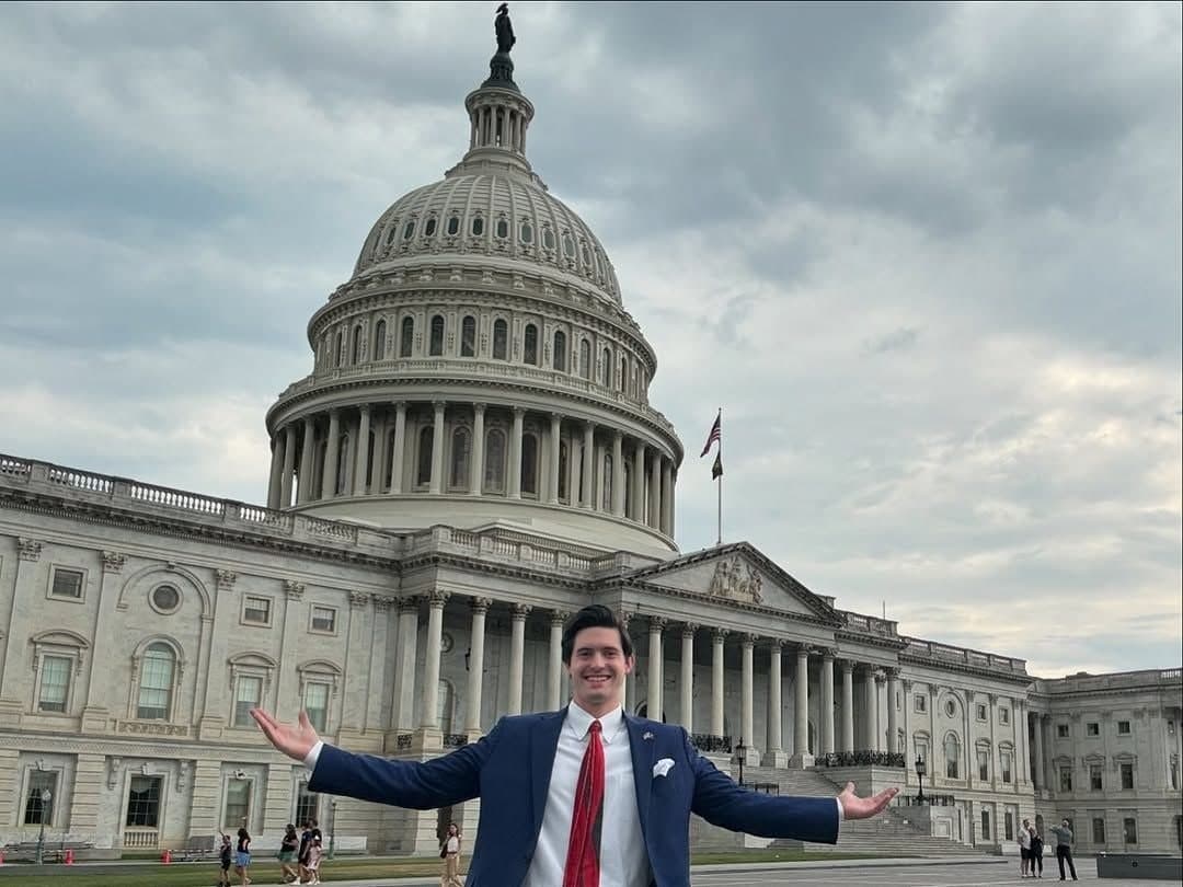 Colin Raby with arms outstretched in front of the U.S. Capitol