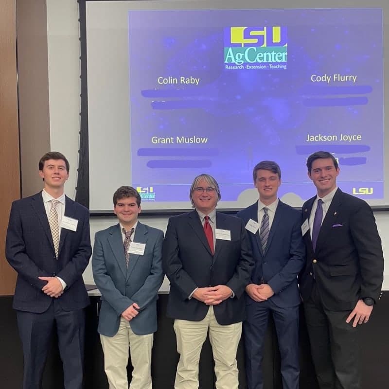Colin Raby with teammates Cody Flurry, Grant Muslow and Jackson Joyce and sponsor Prof. Stephenson in front of their FarmSmart AI presentation at LSU's first AI Showcase