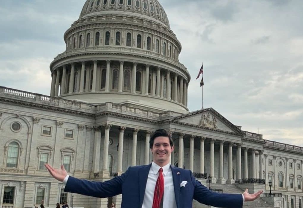 Colin Raby with arms outstretched in front of the U.S. Capitol in Washington, D.C.