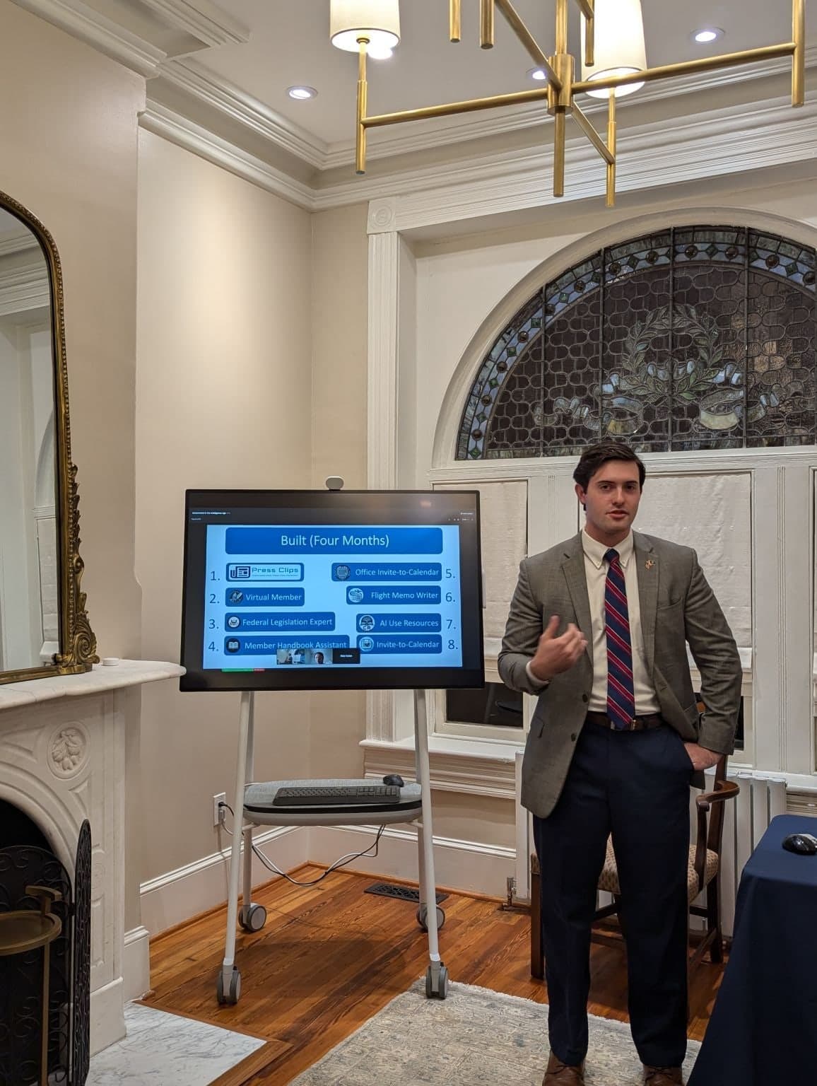 Colin Raby presenting beside a screen in a wood-paneled room at the Sunwater Institute