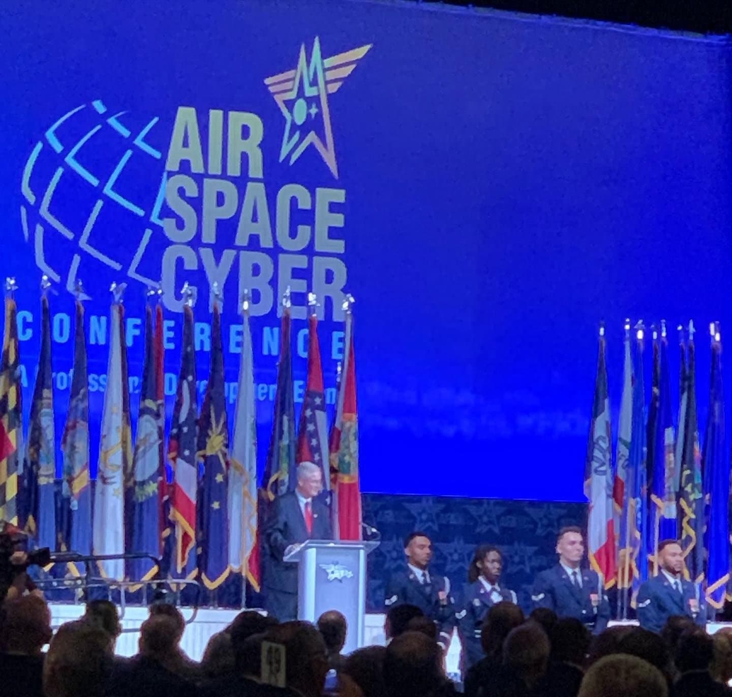 The Air, Space & Cyber Conference main stage, flags lining the stage beneath the conference logo